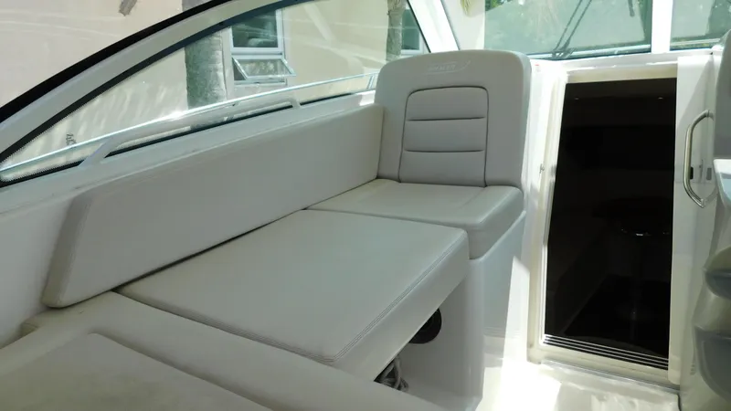 Slide: The Image of 2017 Boston Whaler 315 Conquest interior with white seating and cabin entrance. - 25