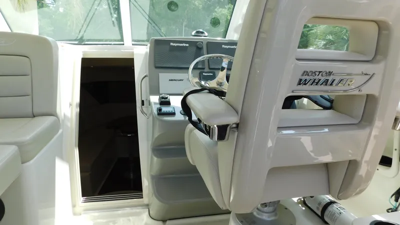 Slide: The Image of 2017 Boston Whaler 315 Conquest helm with steering wheel and controls. - 26