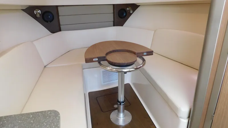 Slide: The Image of 2017 Boston Whaler 315 Conquest cabin interior with seating and table. - 3