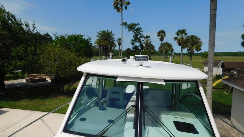 Slide: The Image of 2017 Boston Whaler 315 Conquest boat with palm trees in the background. - 30