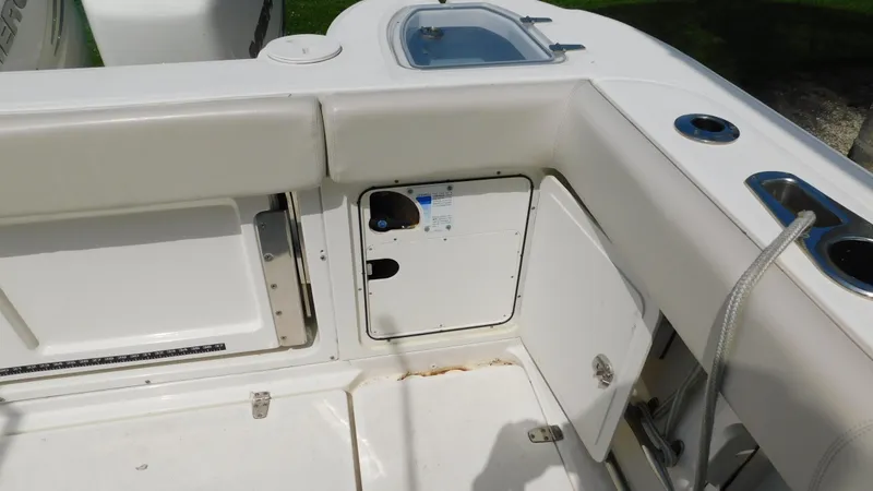 Slide: The Image of 2017 Boston Whaler 315 Conquest boat interior, featuring storage compartments and seating area. - 34