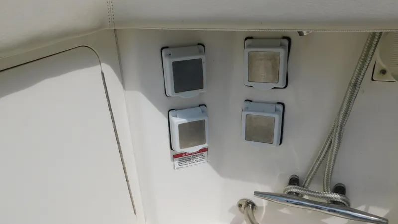 Slide: The Image of 2017 Boston Whaler 315 Conquest boat panel with four covered switches and ropes. - 35