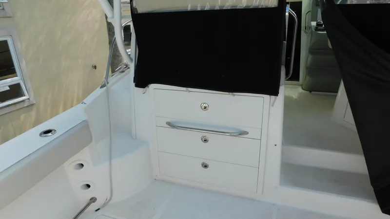 Slide: The Image of 2017 Boston Whaler 315 Conquest interior with storage drawers and seating area. - 36