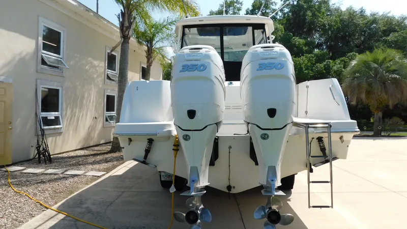 Slide: The Image of 2017 Boston Whaler 315 Conquest with twin outboard engines, parked on a sunny driveway. - 47