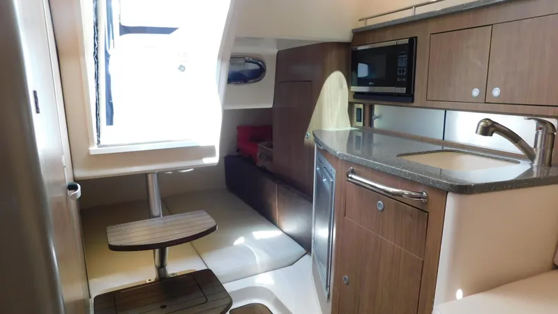 Slide: The Image of Interior of 2017 Boston Whaler 315 Conquest boat with kitchenette and seating area. - 8
