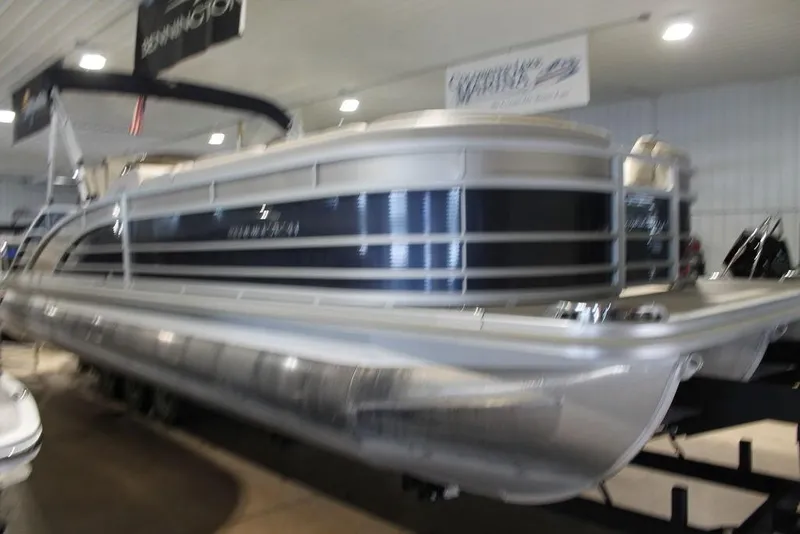 Slide: The Image of 2018 Bennington 25RSB pontoon boat displayed indoors, showcasing sleek design and modern features. - 0