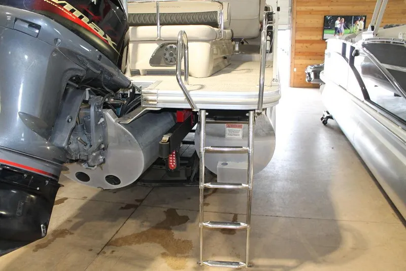 Slide: The Image of 2018 Bennington 25RSB pontoon boat with ladder and outboard motor in a garage. - 14