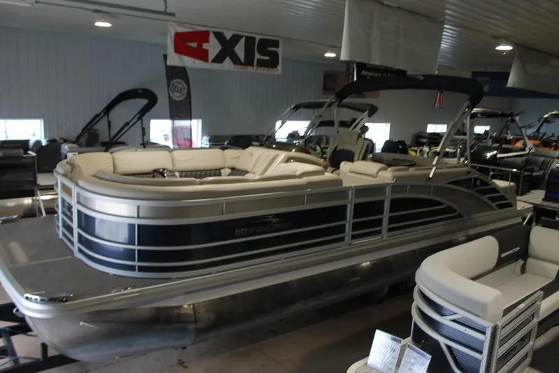 Slide: The Image of 2018 Bennington 25RSB pontoon boat displayed indoors, featuring sleek design and comfortable seating. - 18