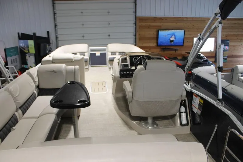 Slide: The Image of 2018 Bennington 25RSB pontoon boat interior with beige seating and steering console. - 2