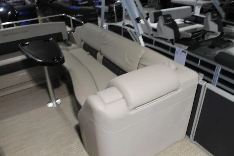 Slide: The Image of 2018 Bennington 25RSB boat interior with beige seating and a small black table. - 5