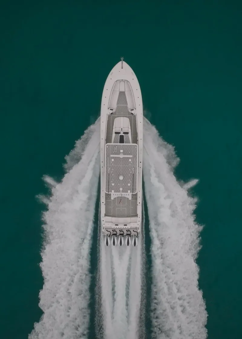 Slide: The Image of Aerial view of 2021 HCB Suenos boat cruising on turquoise water. - 10