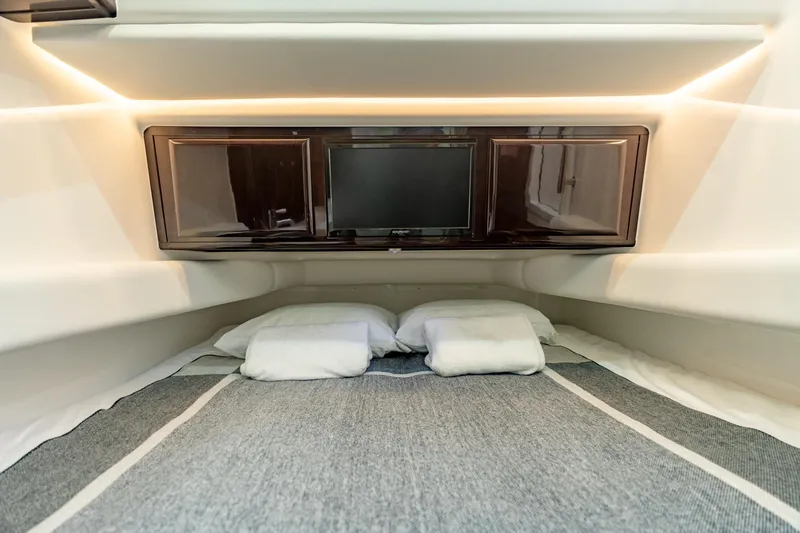 Slide: The Image of 2021 HCB Suenos cabin interior with bed, pillows, and TV. - 15