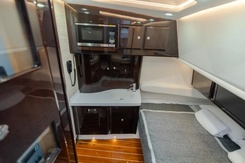 Slide: The Image of 2021 HCB Suenos interior with kitchenette, microwave, and cozy sleeping area. - 16