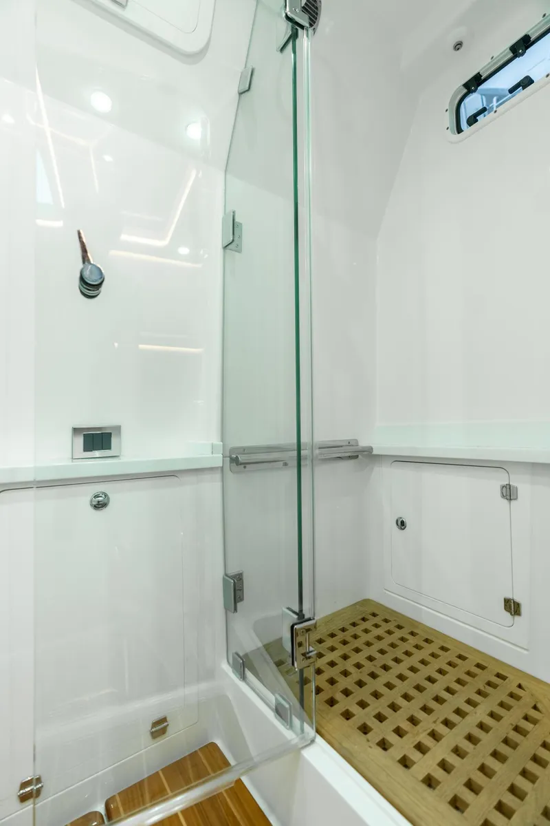 Slide: The Image of Luxurious shower area in 2021 HCB Suenos boat with glass door and wooden floor. - 19