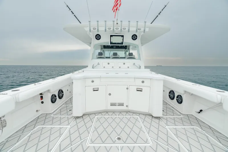 Slide: The Image of 2021 HCB Suenos boat deck with fishing rods, ocean view, and American flag. - 25
