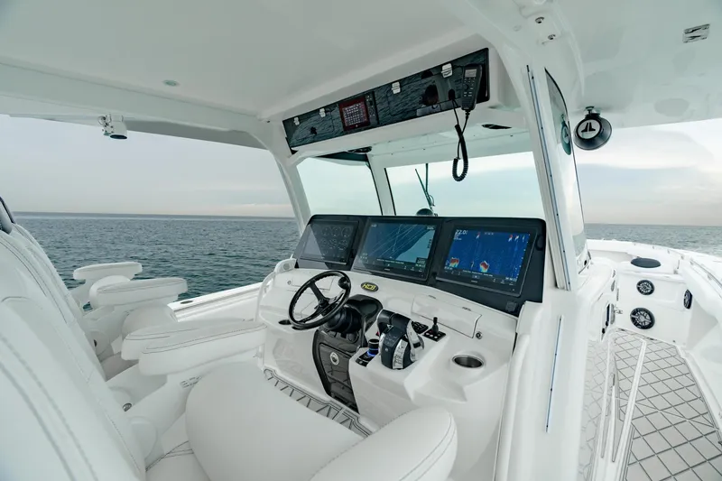 Slide: The Image of 2021 HCB Suenos boat cockpit with advanced navigation screens and luxurious white seating. - 30