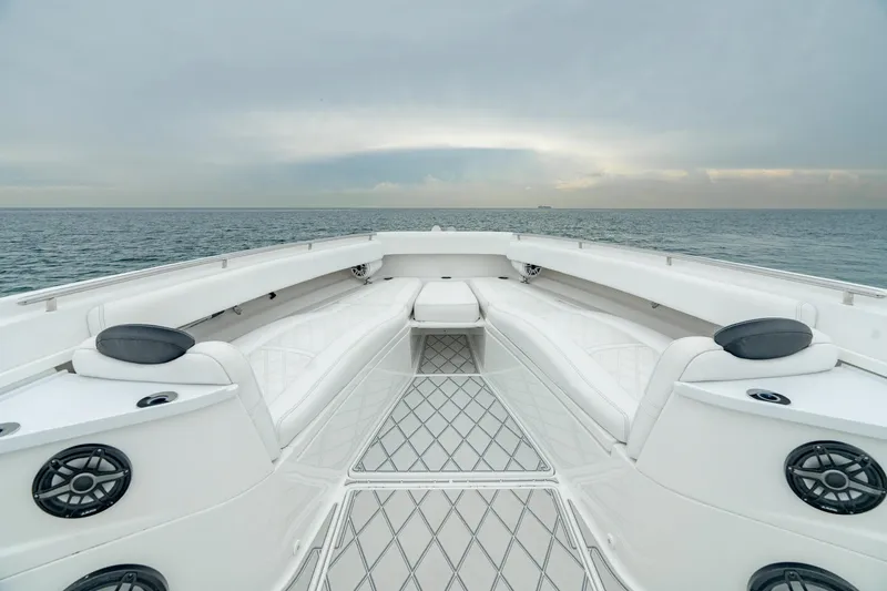 Slide: The Image of 2021 HCB Suenos boat interior with white seating, ocean view, and overcast sky. - 38