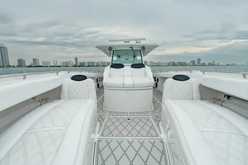 Slide: The Image of 2021 HCB Suenos boat with luxurious white seating and city skyline in the background. - 39