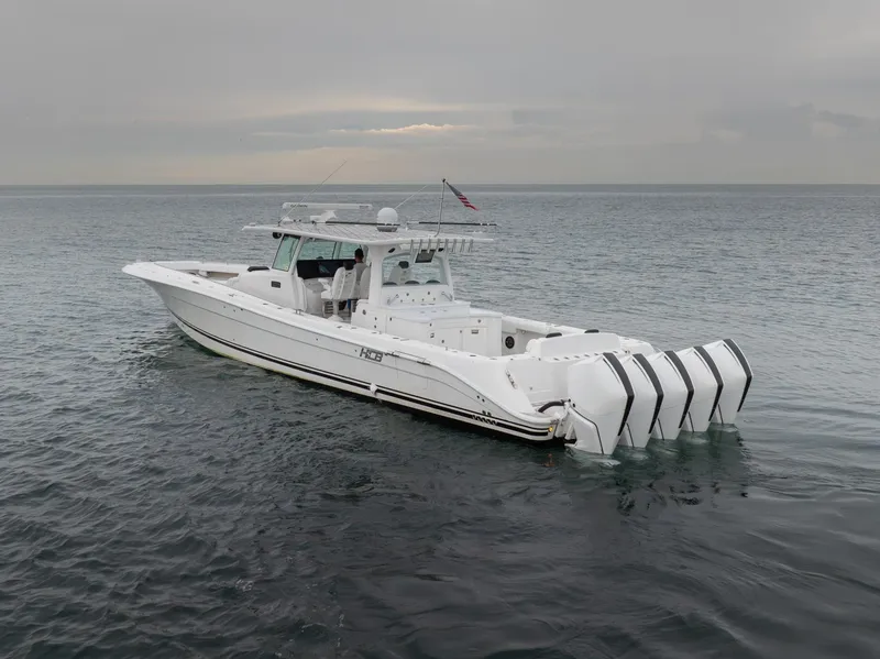 Slide: The Image of 2021 HCB Suenos boat with multiple engines on calm water under cloudy sky. - 4