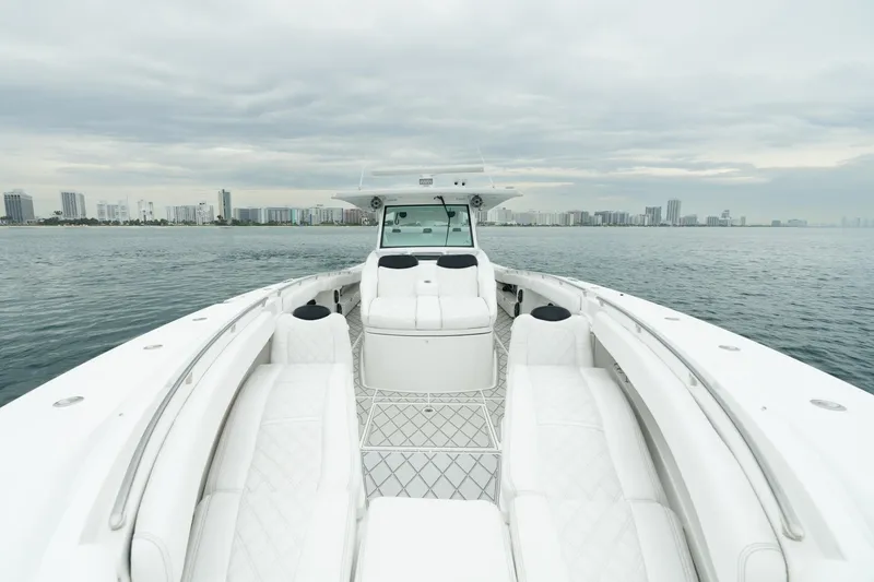 Slide: The Image of 2021 HCB Suenos boat with luxurious seating, cruising on calm waters near a city skyline. - 40