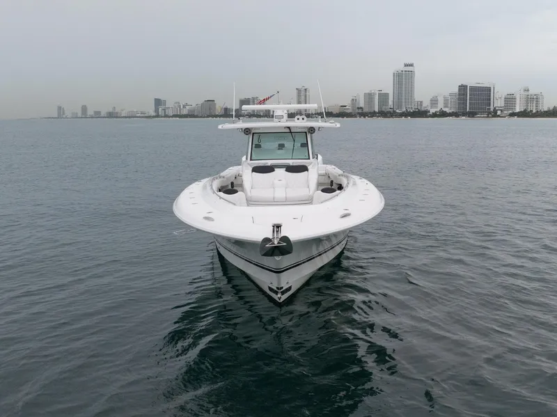 Slide: The Image of 2021 HCB Suenos boat on calm water with city skyline in background. - 6