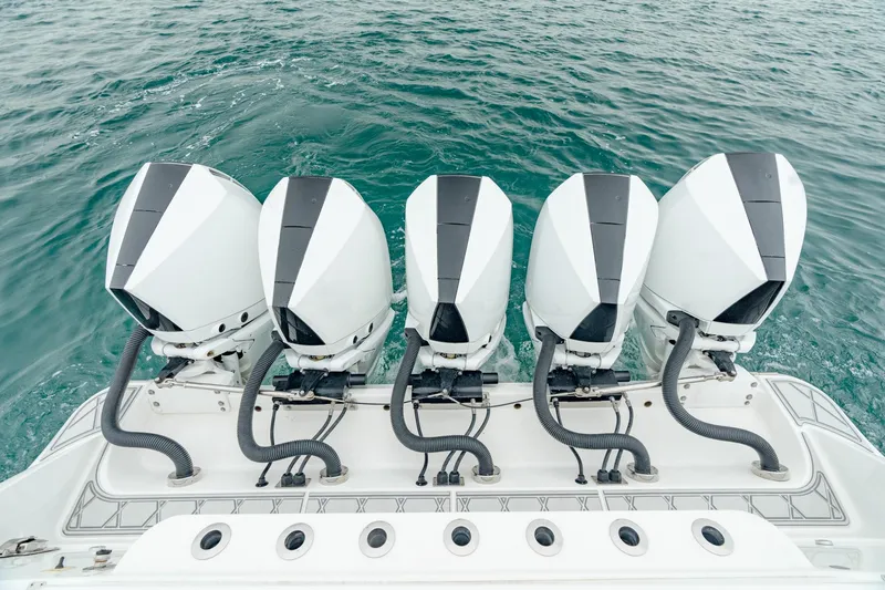 Slide: The Image of Four powerful outboard engines on a 2021 HCB Suenos boat, floating on clear blue water. - 9