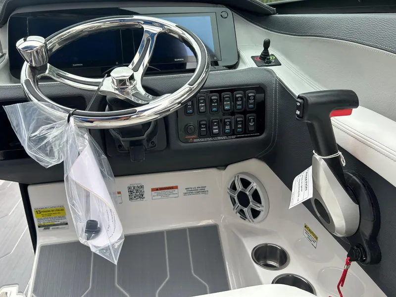 Slide: The Image of 2026 Regal LX4 boat dashboard with steering wheel, control panel, and throttle lever. - 12