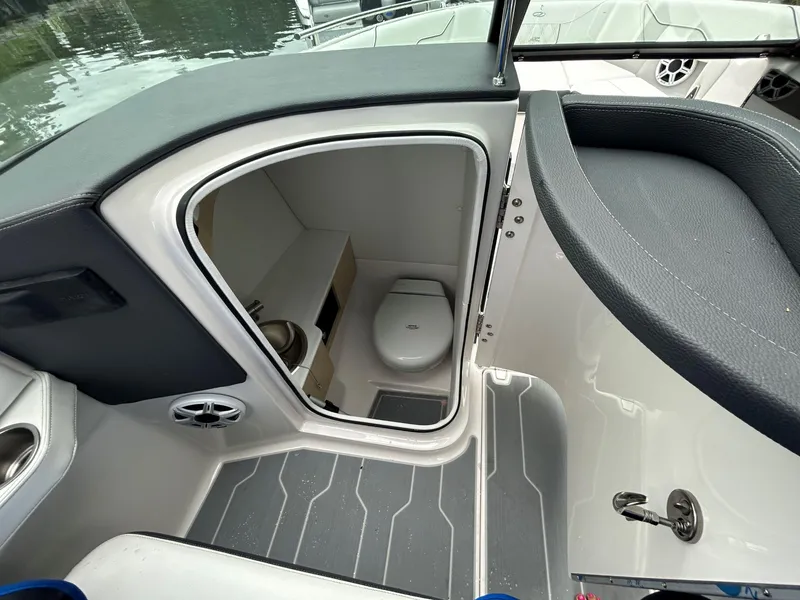 Slide: The Image of Interior of 2026 Regal LX4 boat featuring a compact bathroom with toilet. - 14