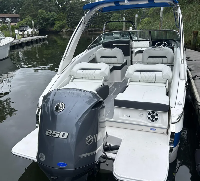 Slide: The Image of 2026 Regal LX4 boat with Yamaha 250 engine docked by the water. - 2