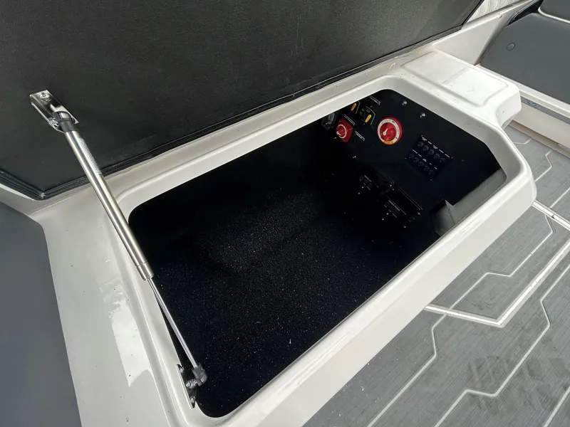 Slide: The Image of Open storage compartment in 2026 Regal LX4 boat, featuring control panel and hydraulic support. - 9