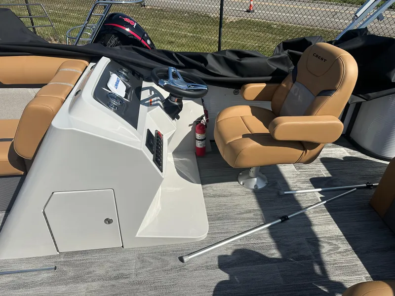 Slide: The Image of 2024 Crest Classic LX 220 boat interior with tan seating and steering console. - 5