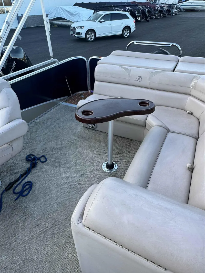 Slide: The Image of 2013 Berkshire 230CL STS pontoon boat with beige seating and a wooden table. - 6