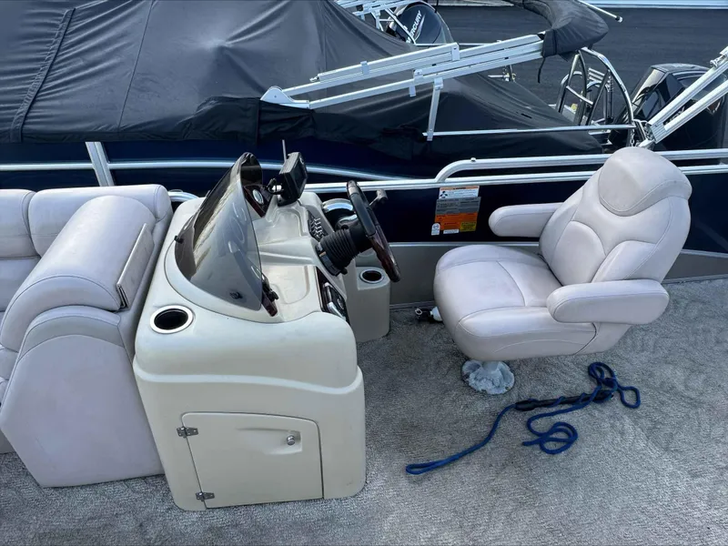 Slide: The Image of 2013 Berkshire 230CL STS boat interior with helm, captain's chair, and covered seating. - 7