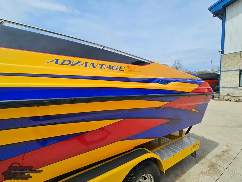 Slide: The Image of 2006 Advantage 28 Victory Bowrider with vibrant yellow, blue, and red design on trailer. - 23