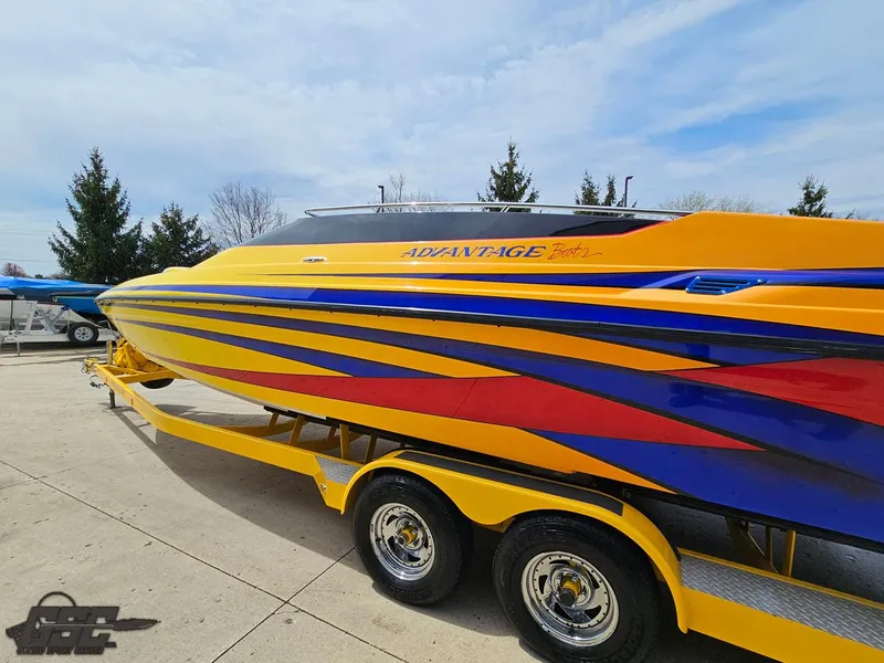 Slide: The Image of 2006 Advantage 28 Victory Bowrider boat with vibrant yellow, blue, and red design on trailer. - 24