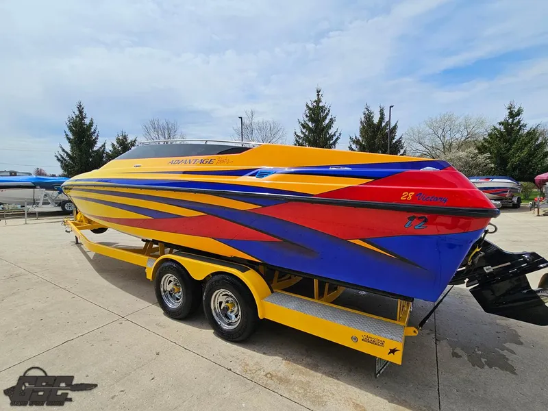 Slide: The Image of 2006 Advantage 28 Victory Bowrider in vibrant yellow, red, and blue on a trailer. - 25