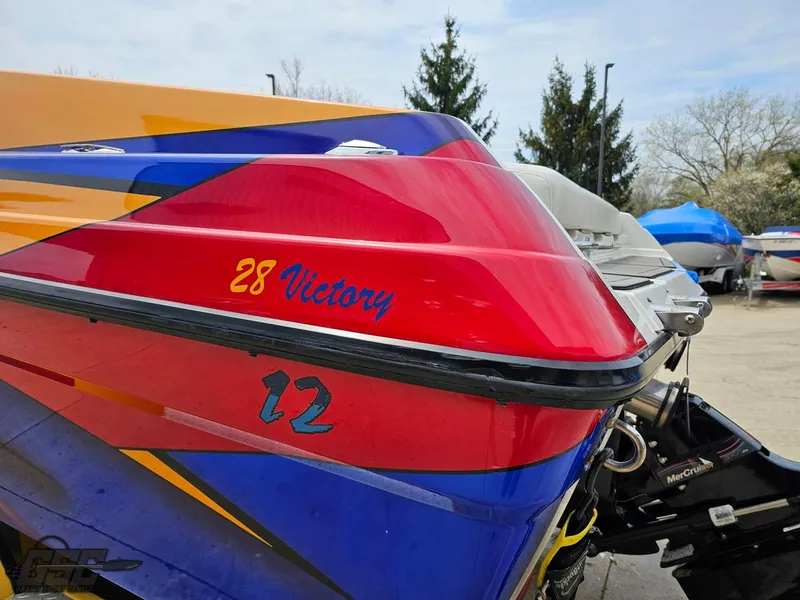 Slide: The Image of 2006 Advantage 28 Victory Bowrider boat with colorful design, parked outdoors. - 27
