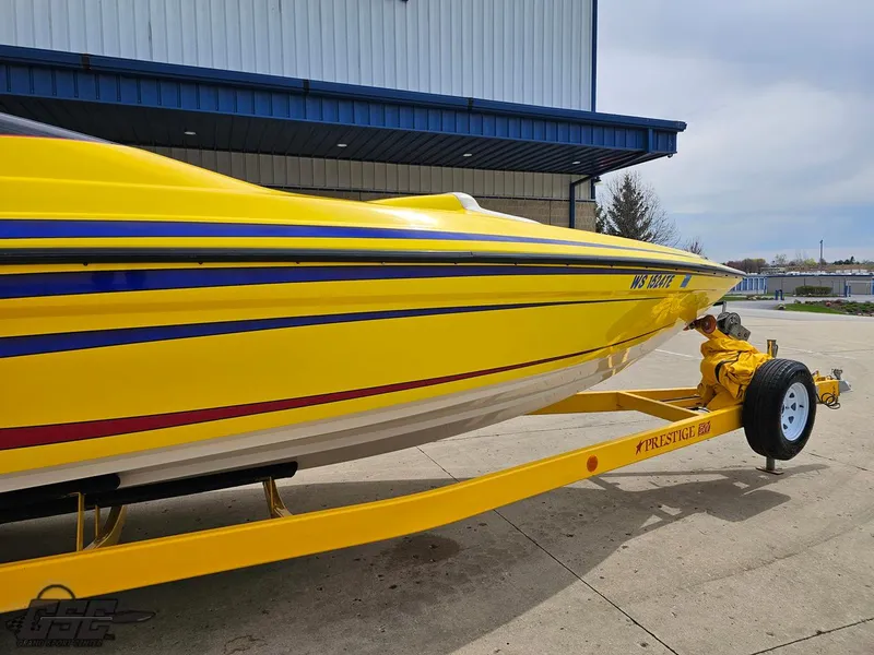 Slide: The Image of Yellow 2006 Advantage 28 Victory Bowrider boat on trailer, parked outside a building. - 5