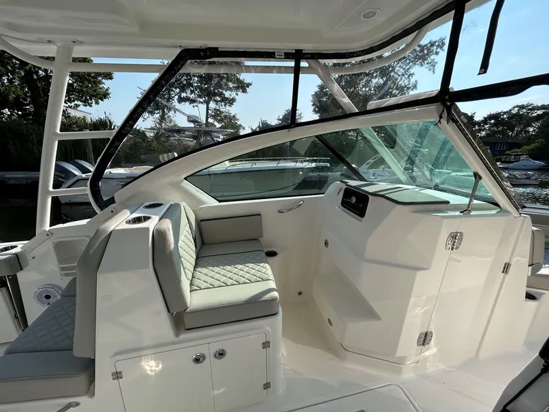 Slide: The Image of 2026 Pursuit DC 266 Dual Console boat interior with cushioned seating and modern design. - 10