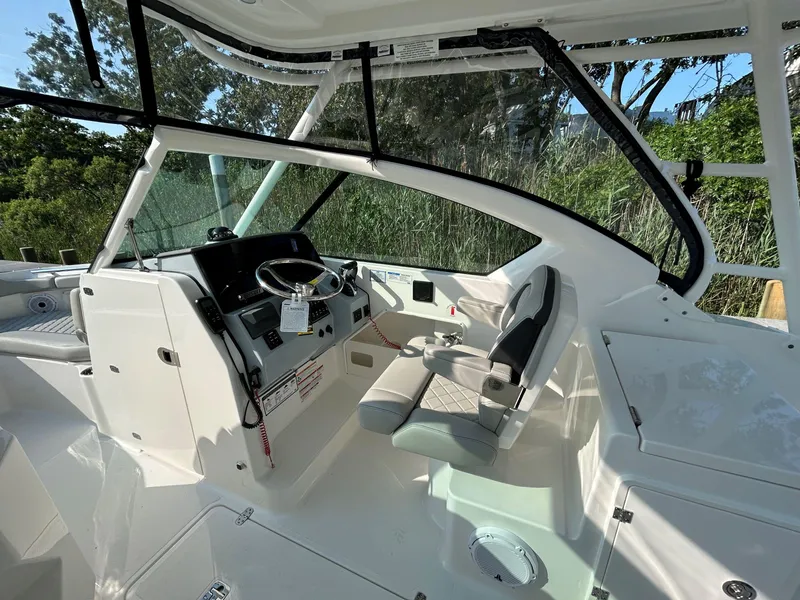 Slide: The Image of 2026 Pursuit DC 266 Dual Console boat interior with steering wheel and seating. - 12