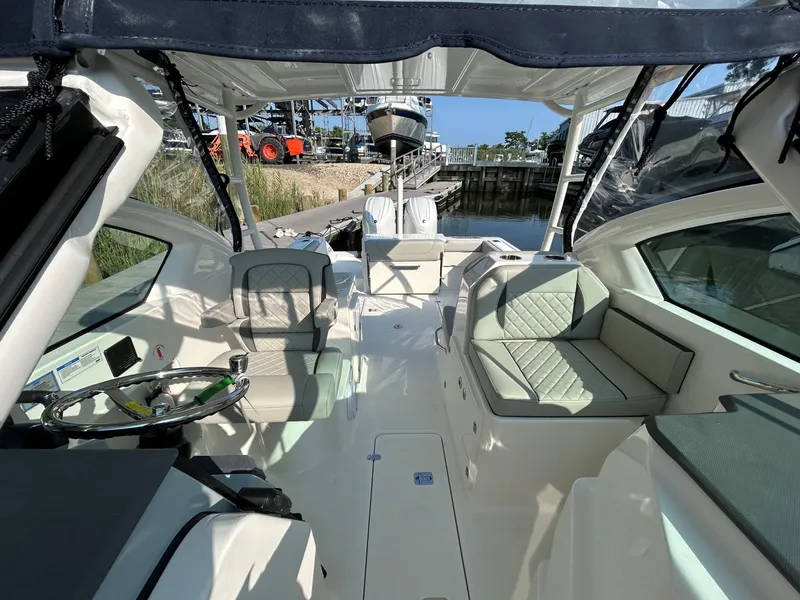 Slide: The Image of 2026 Pursuit DC 266 Dual Console boat interior with seating and steering wheel. - 19