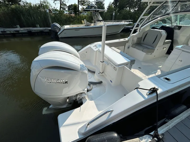 Slide: The Image of 2026 Pursuit DC 266 Dual Console boat with twin Yamaha engines docked in marina. - 2