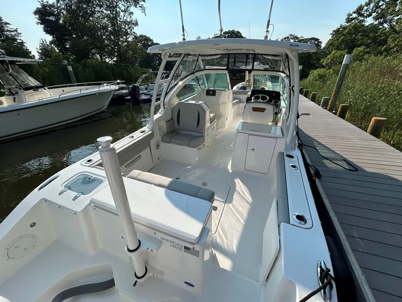 Slide: The Image of 2026 Pursuit DC 266 Dual Console boat docked, showcasing spacious seating and sleek design. - 3