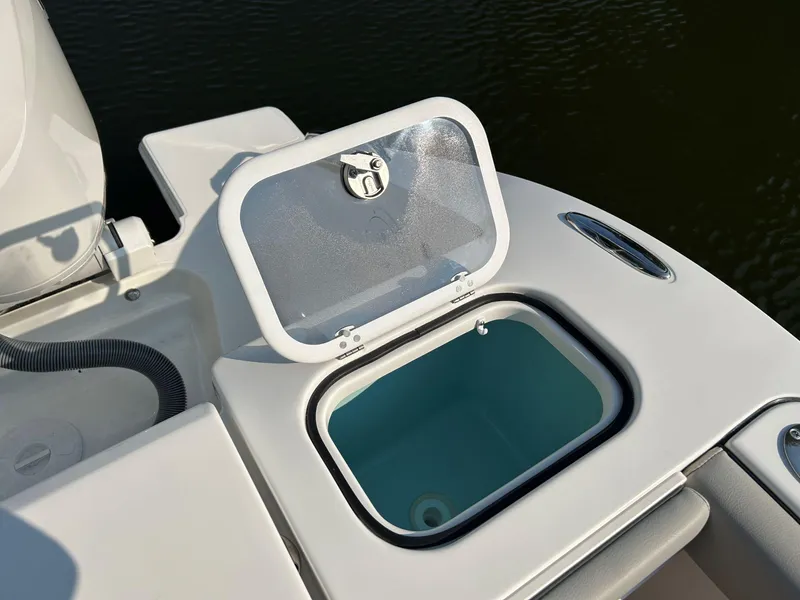 Slide: The Image of Open storage compartment on 2026 Pursuit DC 266 Dual Console boat. - 7