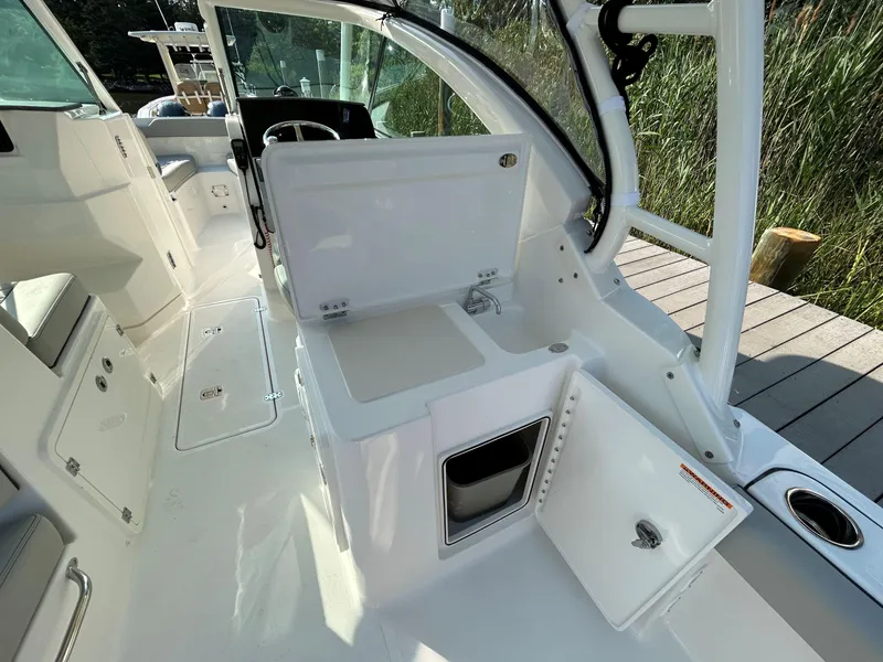 Slide: The Image of 2026 Pursuit DC 266 Dual Console boat interior with open storage compartments and seating. - 8