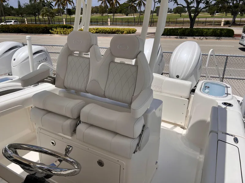 Slide: The Image of 2025 Key West 260 CC boat interior with white cushioned seating and steering wheel. - 13