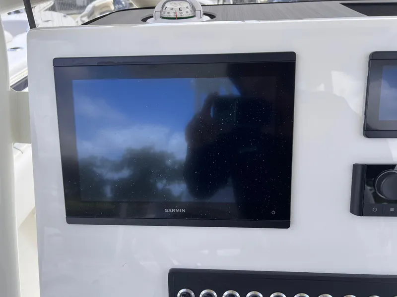 Slide: The Image of 2025 Key West 260 CC boat dashboard with Garmin display and controls. - 3
