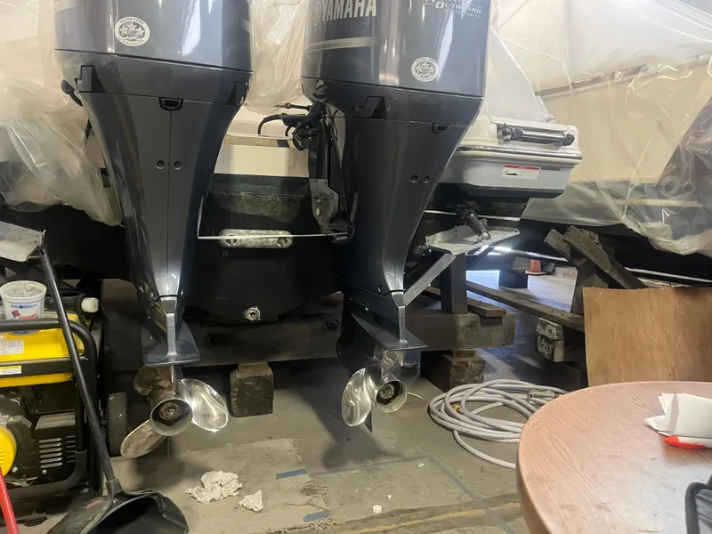 Slide: The Image of 2021 Robalo R272 Center Console with dual Yamaha outboard motors in a workshop setting. - 24