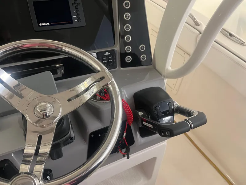 Slide: The Image of 2021 Robalo R272 Center Console helm with steering wheel and control panel. - 28