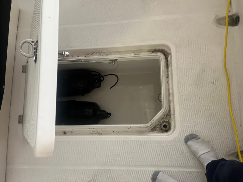 Slide: The Image of 2021 Robalo R272 Center Console storage compartment with open hatch and visible equipment. - 39